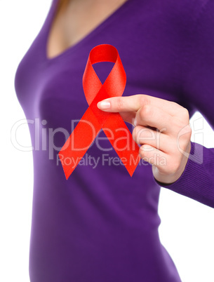 Woman is holding the red awareness ribbon