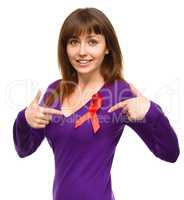 Woman is pointing to the red awareness ribbon