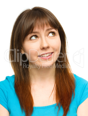 Young happy woman is looking up and smile