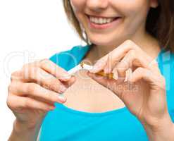 Young woman is breaking a cigarette