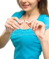 Young woman is breaking a cigarette