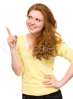 Portrait of a young woman pointing to the left