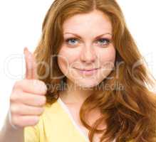 Woman is showing thumb up gesture