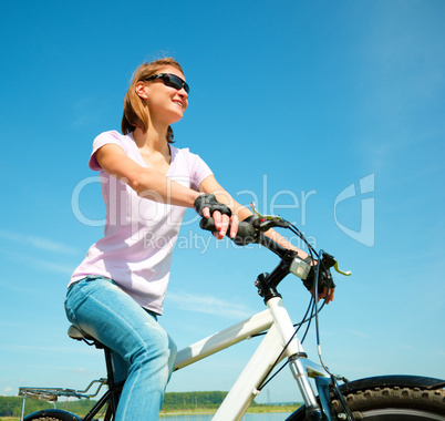 Young woman is sitting on her bicycle