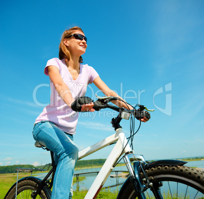 Young woman is sitting on her bicycle