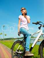 Young woman is sitting on her bicycle