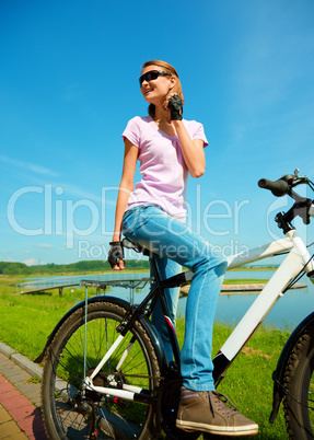 Young woman is sitting on her bicycle