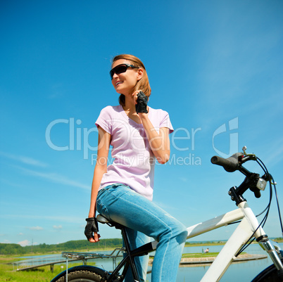 Young woman is sitting on her bicycle