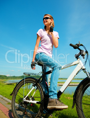 Young woman is sitting on her bicycle