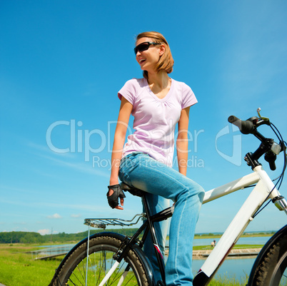 Young woman is sitting on her bicycle