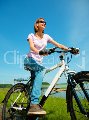 Young woman is sitting on her bicycle