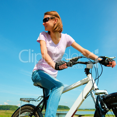 Young woman is sitting on her bicycle