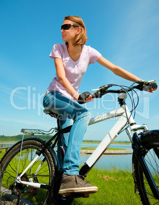 Young woman is sitting on her bicycle