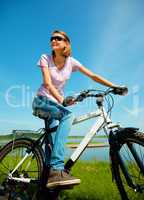 Young woman is sitting on her bicycle