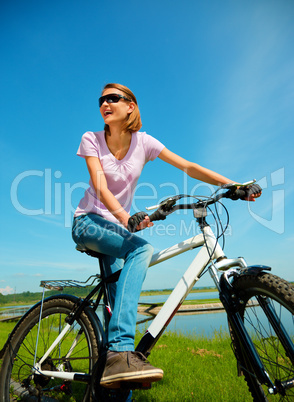 Young woman is sitting on her bicycle