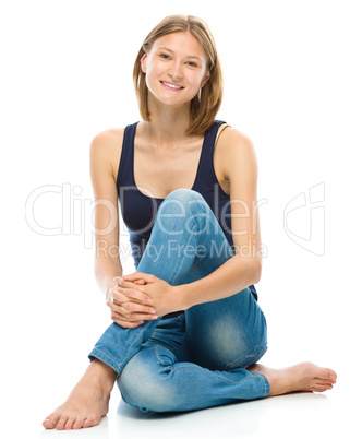 Young happy woman is sitting on the floor