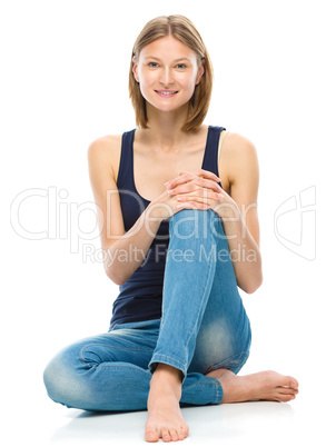 Young happy woman is sitting on the floor