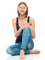 Young happy woman is sitting on the floor