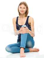 Young happy woman is sitting on the floor