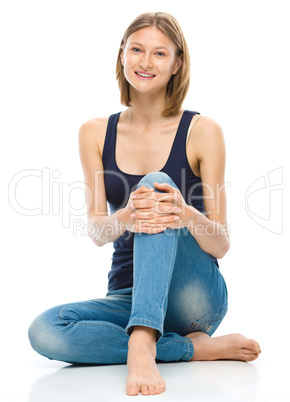 Young happy woman is sitting on the floor