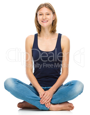 Young happy woman is sitting on the floor