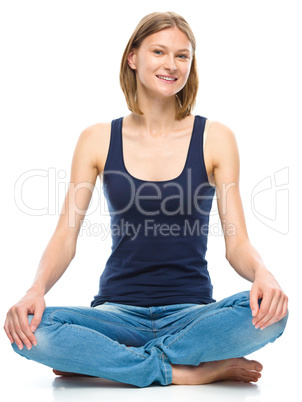 Young happy woman is sitting on the floor