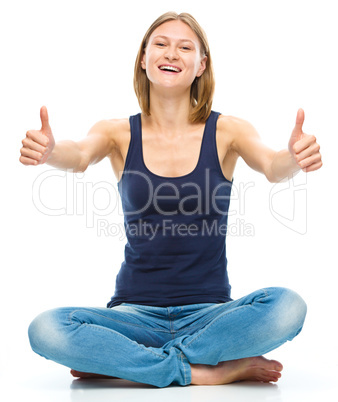 Young happy woman is showing thumb up sign