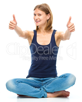 Young happy woman is showing thumb up sign