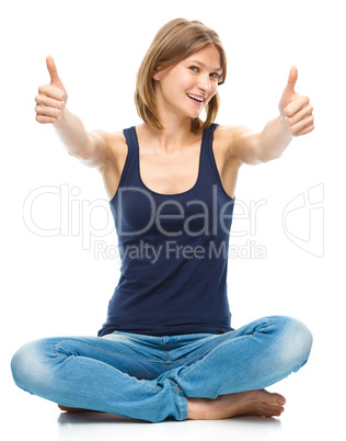 Young happy woman is showing thumb up sign