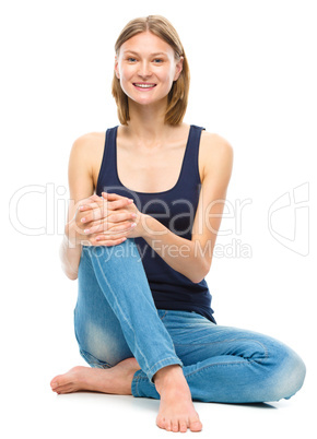 Young happy woman is sitting on the floor