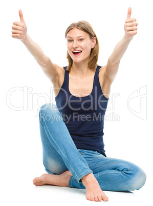 Young happy woman is showing thumb up sign