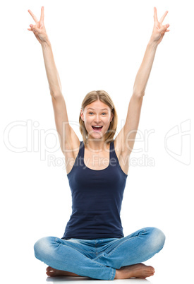 Young happy woman is sitting on the floor