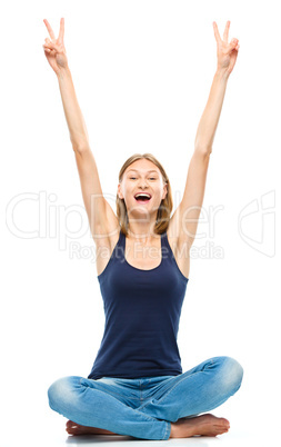 Young happy woman is sitting on the floor