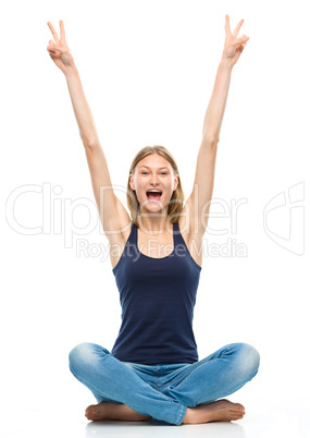 Young happy woman is sitting on the floor