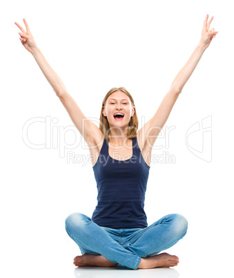 Young happy woman is sitting on the floor