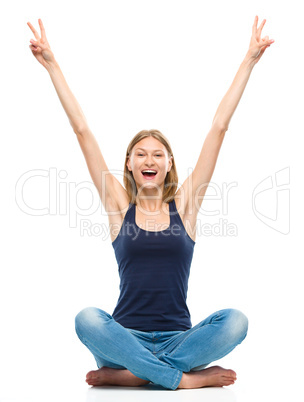 Young happy woman is sitting on the floor