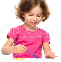 Little girl is painting with gouache