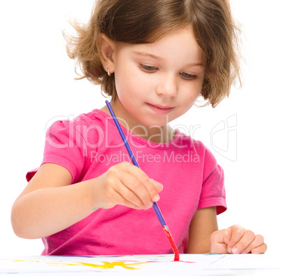 Little girl is painting with gouache