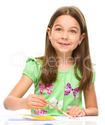 Little girl is painting with gouache