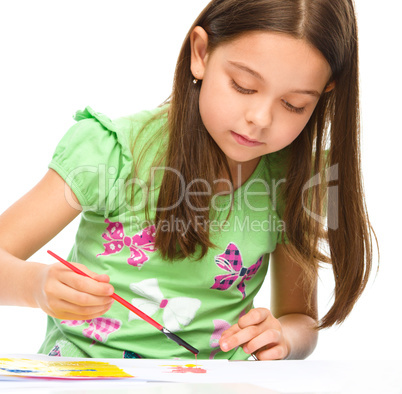 Little girl is painting with gouache