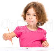 Little girl is painting with gouache