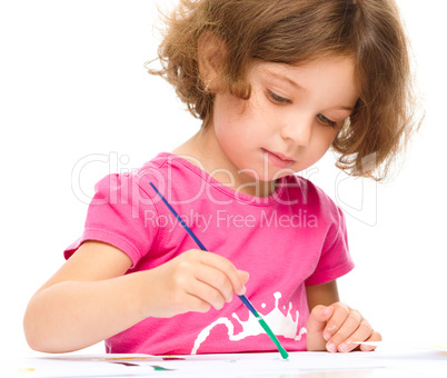 Little girl is painting with gouache