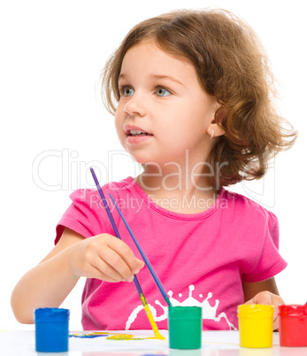 Little girl is painting with gouache