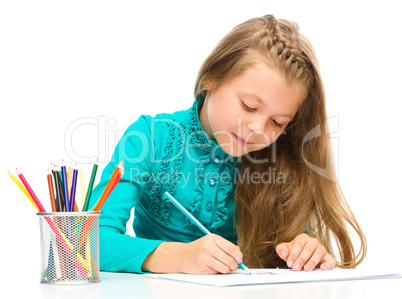 Little girl is drawing using pencils Little girl is drawing using pencils