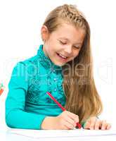 Little girl is drawing using pencils