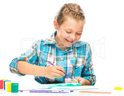 Little girl is drawing using pencils