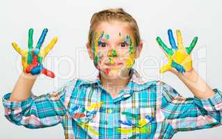 Portrait of a cute girl playing with paints