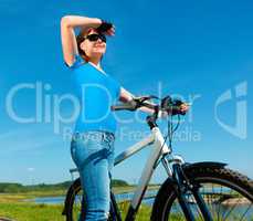 Young woman is standing in front of her bicycle