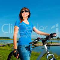 Young woman is standing in front of her bicycle