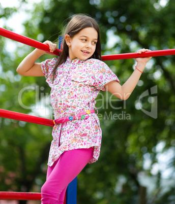 Cute little girl is playing in playground